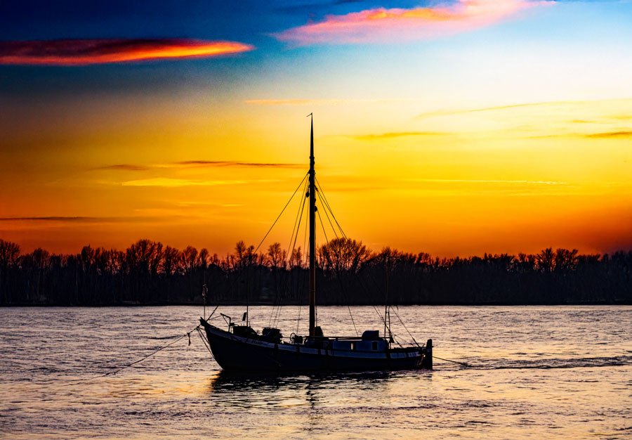 Fischerboot auf dem Rhein bei Sonnenuntergang – stimmungsvolle Aufnahme bei Rees am Niederrhein